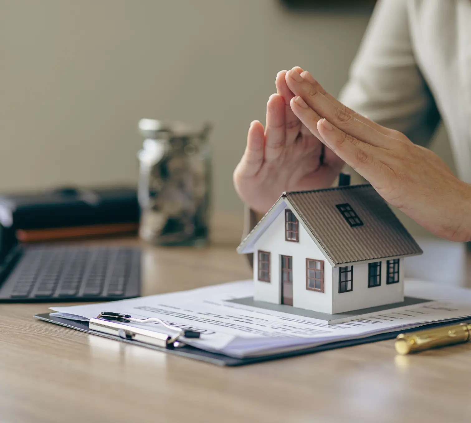 Investment Managment bei der LHI Leasing GmbH. Bild ein paar Hände, die das Modell eines Hauses schützen um Sicherheit zu symbolisieren.
