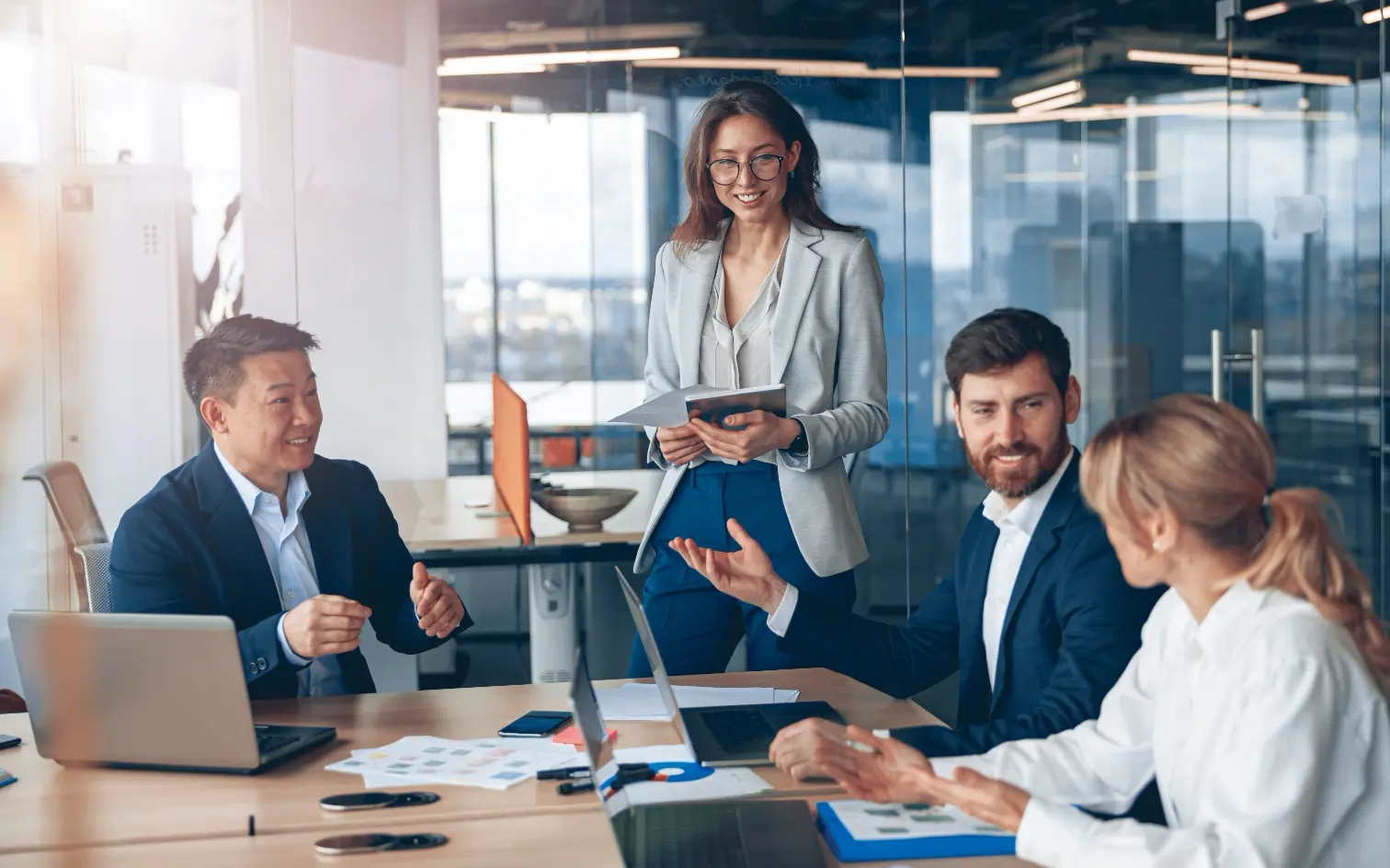 LHI Immobilien. Bild zeigt verschiedene Businesspersonen an einem Konferenztisch, die sich unterhalten.